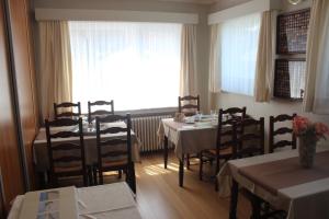 une salle à manger avec des tables et des chaises ainsi qu'une fenêtre dans l'établissement B&B Vanloo, à Middelkerke