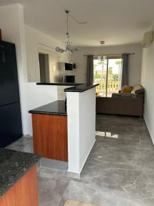 a kitchen with a counter top and a living room at Holiday Mandria apt with pool in Paphos