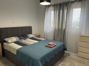 a bedroom with a bed with two towels on it at Holiday Mandria apt with pool in Paphos +4 photos