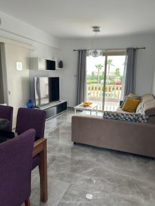 a living room with a bed and a table and chairs at Holiday Mandria apt with pool in Paphos
