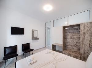 a room with two chairs and a table and a tv at Filippa City Apartments - Lefkada Town Center in Lefkada