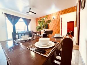 une salle à manger avec une table et de la vaisselle dans l'établissement Africa Mbweni Apartment, à Kiembi Samaki