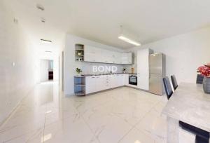 a large kitchen with white cabinets and a large tile floor at Veľký rodinný dom in Senec