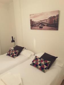 two beds in a room with a painting on the wall at 2066-Apt 2 bedrooms on beach, tenis, gym, pool in Manilva