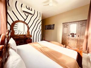 a bedroom with a bed and a zebra themed wall at Africa Mbweni Apartment in Kiembi Samaki