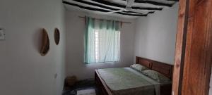 sypialnia z łóżkiem i oknem w obiekcie Karikila w mieście Paje