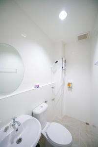 a white bathroom with a toilet and a sink at Nut Home Hostel in Ban Ko