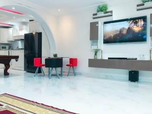 sala de estar con TV de pantalla plana en la pared en Luxury home with class, en Accra