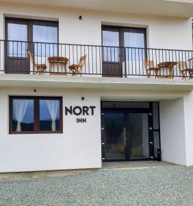 - un bâtiment d'auberge nord avec des chaises sur le balcon dans l'établissement Nort Inn, à Tău Bistra