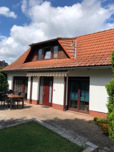 uma casa com um telhado laranja e um pátio em Ferienhaus "Buddelschiff" em Ueckermünde