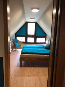 um quarto com uma cama com lençóis azuis e uma janela em Ferienhaus "Buddelschiff" em Ueckermünde