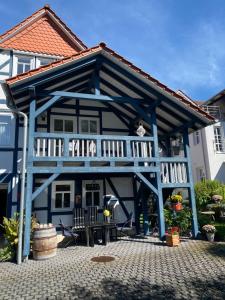 uma casa azul com um alpendre e um deque em PARADISE GARDEN em Bad Sooden-Allendorf