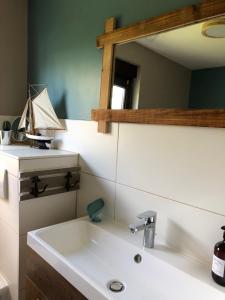 un bagno con lavandino e specchio di Ferienhaus "Buddelschiff" a Ueckermünde Altre 35 foto