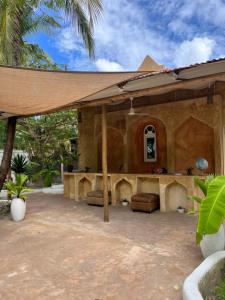 an outdoor patio with awning on a house at Karanga Bungalows in Michamvi +28 photos
