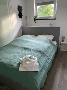 um quarto com uma cama com lençóis verdes e uma janela em Apartment BB43 em Düren - Eifel