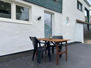 uma mesa de madeira e cadeiras sentadas num pátio em Apartment BB43 em Düren - Eifel