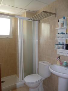 y baño con aseo, ducha y lavamanos. en 2010-Superb apt 2 bedrooms in complex with pool, en Manilva