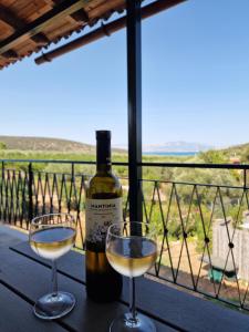 una bottiglia di vino e due bicchieri su un tavolo di Grieks vakantiehuis To Kalokairi a Kalamákion