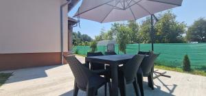 a table with chairs and an umbrella on a patio at Casa Emy in Râmnicu Vâlcea +3 photos