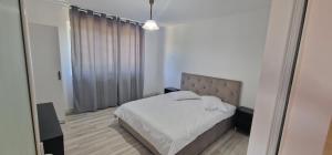 a bedroom with a bed and a large window at Casa Emy in Râmnicu Vâlcea