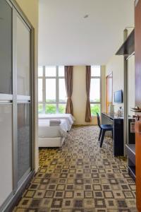 a hotel room with a bed and a desk at Fumah Hotel Shah Alam in Shah Alam