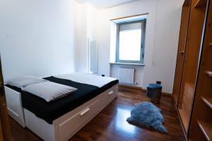 Schlafzimmer mit einem Bett, einem Fenster und einem Teppich in der Unterkunft New apartment Trento (parking) in Trient