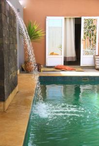 a swimming pool with a fountain in a house at GreenLand in Bir Jedíd Saint-Hubert