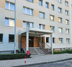 un edificio con una escalera frente a un edificio en Apartament w centrum miasta z balkonem, en Jastrzębie-Zdrój