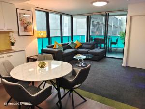 a living room with a table and a couch at Adelaide City Loft in Adelaide