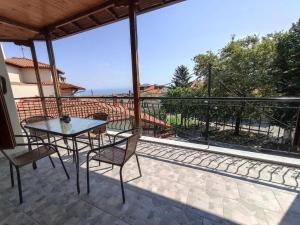 a patio with a table and chairs on a balcony at ZeusPlace Anastasia's Apartment 1 in Litochoro