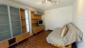 a small bedroom with a bed and a television at Panoramer in Théoule-sur-Mer