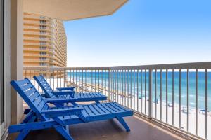 - deux chaises bleues sur un balcon donnant sur l'océan dans l'établissement Seychelles 601, à Panama City Beach