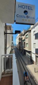 Ein Mann, der eine Straße entlang fährt, neben einem Hotel in der Unterkunft Hotel Costa Brava in Roses