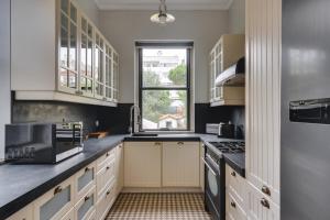 a kitchen with white cabinets and a window at Porto Premium Villa in Porto