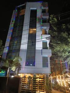 a tall white building with christmas lights on it at Hotel Mayfair Tower in Kolkata