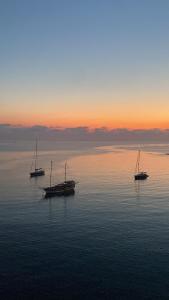 trois bateaux assis dans l'eau au coucher du soleil dans l'établissement F1 2 St Julians, Private room, bathroom & living shared, à San Ġiljan