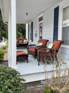 a porch with two wicker chairs on a house at Farmhouse 316 of Milton in Milton