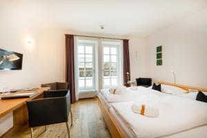 a hotel room with two beds and a desk at Schloss Lautrach in Lautrach