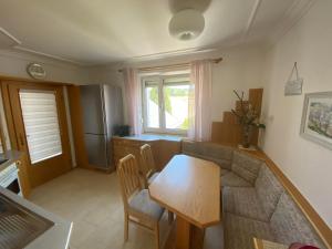 a living room with a table and a kitchen at Ferienwohnung Nussbaumblick in Ottensheim