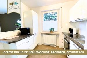 eine Küche mit weißen Schränken und einem Fenster in der Unterkunft Semper Suite No1 - 2Zi Fewo 1-4 Pers, Balkon, Parkplatz, Hofgartennähe in Bayreuth