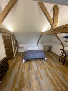 1 dormitorio con 1 cama en una habitación con suelo de madera en Appartement au manoir de la grande vigne Mayenne, en Mayenne
