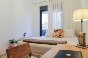 a hotel room with a bed and a table and a couch at Phos Luxury Apartment in Lefkada