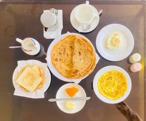 a table with plates of breakfast food on it at HOTEL ROYAL ONE in Multan