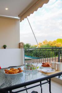 a table with plates of food on a balcony at Phos Luxury Apartment in Lefkada