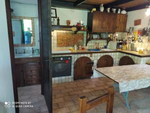 una cocina con armarios de madera y una mesa. en b&b chalet la vigna intera struttura en Scurcola Marsicana