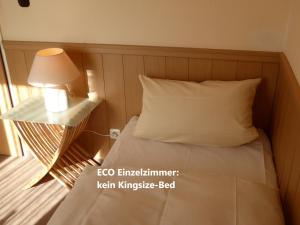 LügdeにあるSonnenhofのランプと枕が備わるドミトリールームのベッド1台分です。