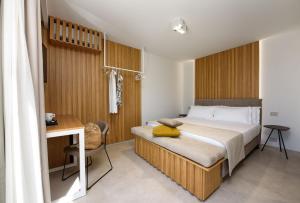 een slaapkamer met een bed en een bureau bij IL MARE DENTRO SUITES in San Vito lo Capo