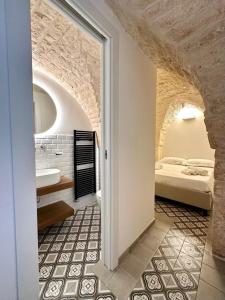 een slaapkamer met een bed en een badkamer met een bad bij Casa Bell'ora in Ostuni