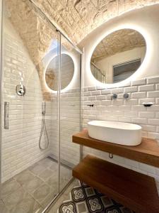 een badkamer met een wastafel en een glazen douche bij Casa Bell'ora in Ostuni