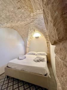 een slaapkamer met een bed in een stenen muur bij Casa Bell'ora in Ostuni